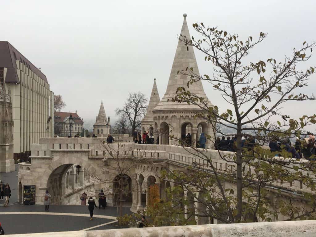 A large, stone, castle like building with a small plaza in the middle.