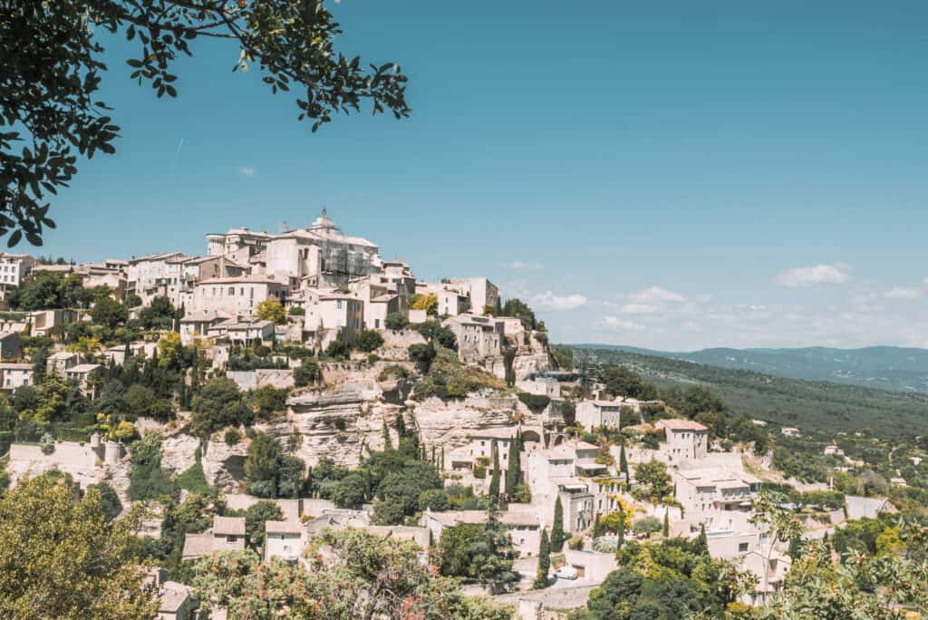 A small city on a hill that is filled with white buildings and houses.
