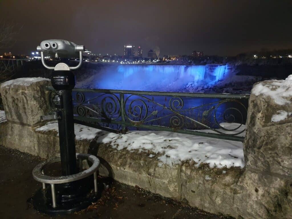 A viewing stand slightly covered in snow overlooking Niagra Falls.